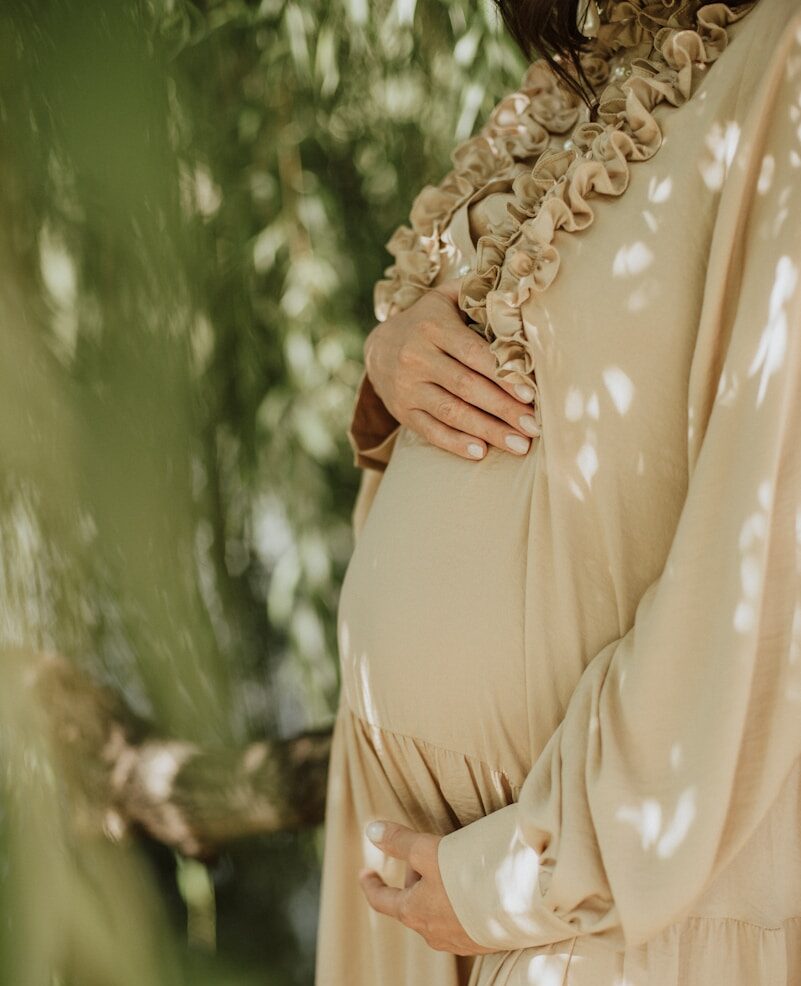 woman in beige and white floral dress wearing gold ring