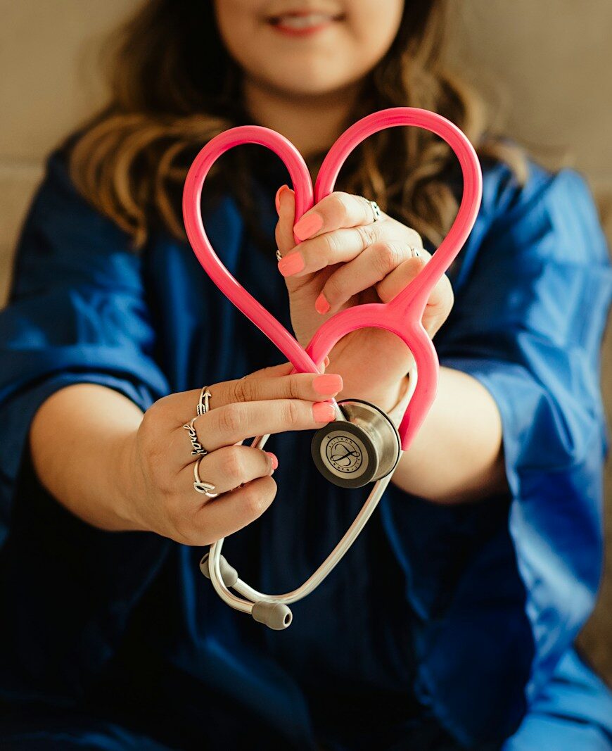 girl in blue jacket holding red and silver ring